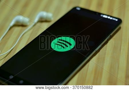 London, Uk, 2020. Flat Lay Of Spotify App Icon On The Smartphone Screen On Display And A Pair Of Ear