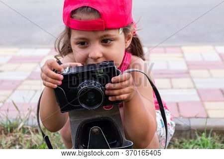 Little Girl Shooting Blog On Retro Photo Camera сlose Up.