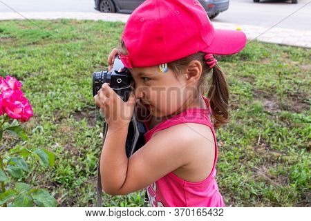 Little Girl Shooting Blog On Retro Photo Camera сlose Up.