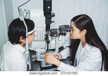 Consultation With An Ophthalmologist. Young Asian Man And Woman Doctor
