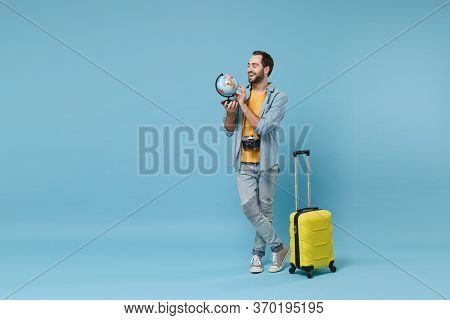 Funny Traveler Tourist Man In Yellow Casual Clothes With Photo Camera, Suitcase Isolated On Blue Bac