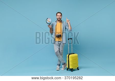 Traveler Tourist Man In Yellow Clothes With Photo Camera Suitcase Isolated On Blue Background. Male 
