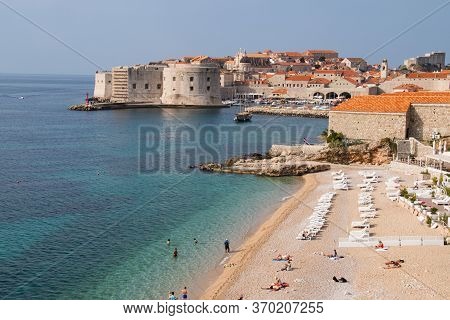Adriatic Beach With Azure, Turqouise And Seagreen Colored Waters With Dubrovnik, Croatia's Walled Ol