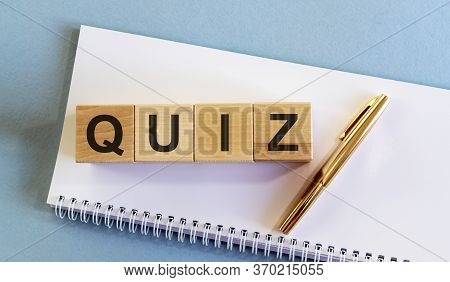 Text Word Inscription Quiz On Cube Blocks With Golden Pen On White Planner Notebook On Blue Backgrou