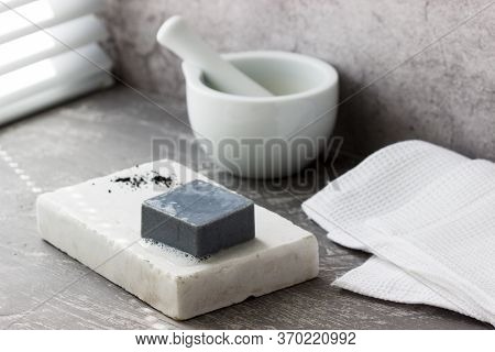 Handmade Soap With Activated Carbon On Marble, Carbon Powder And A Cotton Towel On A Gray Background