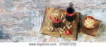 Kharkiv / Ukraine - June 6 2020: Selective Focus. Macro. Coca Cola Bottle With Peanuts. Peanuts With