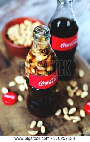 Kharkiv / Ukraine - June 6 2020: Selective Focus. Macro. Coca Cola Bottle With Peanuts. Peanuts With