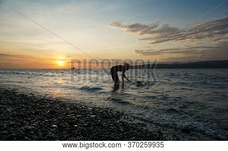 Banyuwangi, Indonesia - May 14, 2020 : A Woman Playing With The Dogs At Watudodol Beach Banyuwangi E