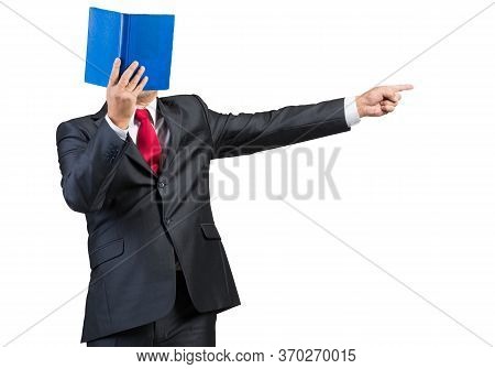 Businessman Covered His Face With Book And Finger Pointing Side. Portrait Of Man In Business Suit An