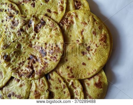 Closeup Of Yellow Color Traditional Dal Obbattu Or Holige In A Plate Isolated On White Background