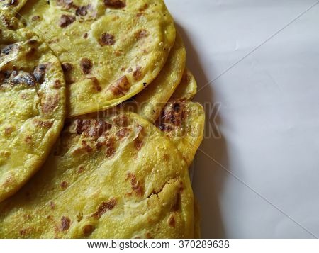 Closeup Of Yellow Color Traditional Dal Obbattu Or Holige In A Plate Isolated On White Background