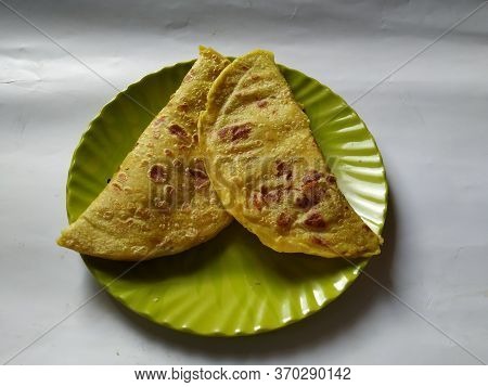 Closeup Of Yellow Color Traditional Dal Obbattu Or Holige In A Plate Isolated On White Background