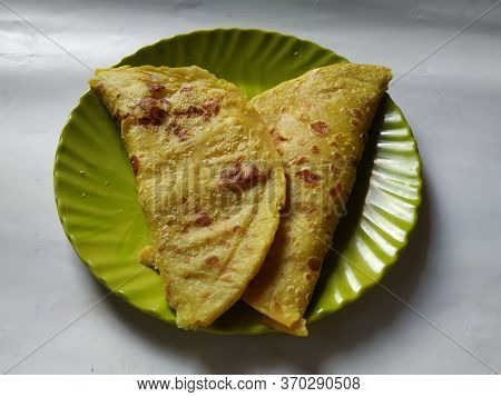 Group Of Yellow Color Traditional Dal Obbattu Or Holige In A Plate Isolated On White Background