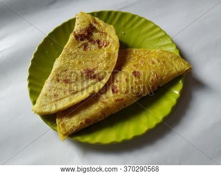 Group Of Yellow Color Traditional Dal Obbattu Or Holige In A Plate Isolated On White Background