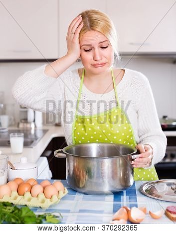 Unhappy Young Woman Preparing Exotic Food With Rank Odour At Kitchen