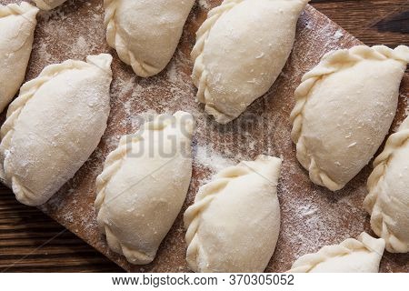 Prepared For Cooking Vareniki, Dumplings, Pierogi On A Floured Wooden Board - Traditional Ukrainian 