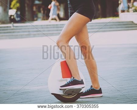 Young Couple Driving On Monowheel In The Park
