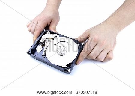A Hand Repairs Hard Drive Isolated On A White Background. Man Hand Fixing Hard Drive, Disc. A Techni
