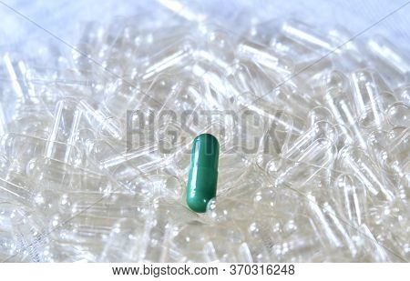 Medical Concept, Green Herbal Medicine On Pile Of Empty Capsules, Use Of Medicinal Plants.