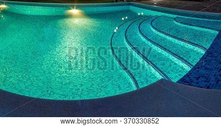 Pool At Night With Pure Blue Water Background. Top View Of Swimming Pool And Floor Texture Panorama 