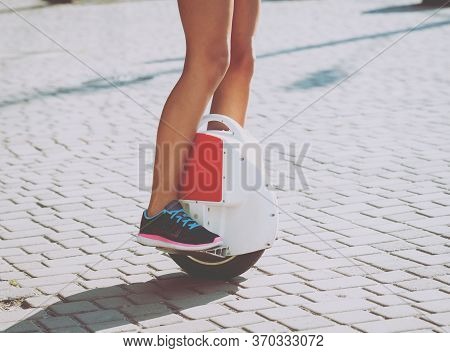 Young Couple Driving On Monowheel In The Park
