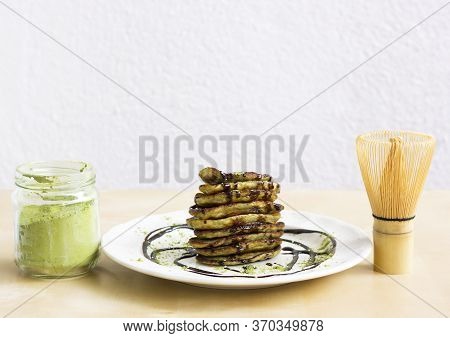 Matcha Tea Green Pancakes. Pile Of Homemade Pancakes With Chocolate And Powred Matcha Between Glass 