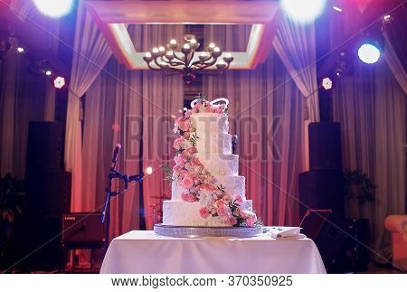 Luxurious White Cake Stands On The Table In The Restaurant. The Holiday Is Coming To An End.