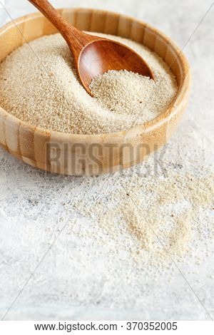 A Bowl Of Raw Fonio Seeds With A Spoon Close Up
