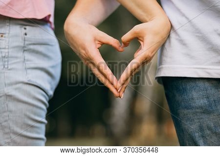 Closeup Of Couple Making Heart Shape With Hands.