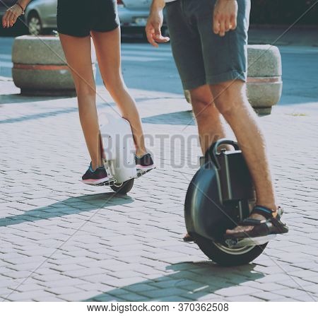 Young Couple Driving On Monowheel In The Park