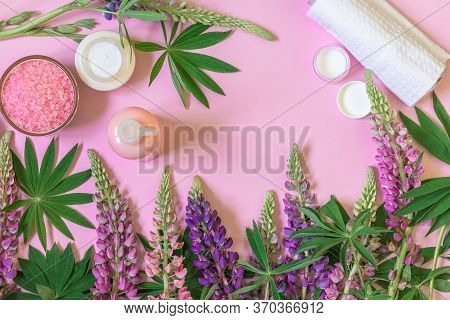 Spa Beauty Cosmetics, Upine Flowers And Green Leaves On A Pink Background.
