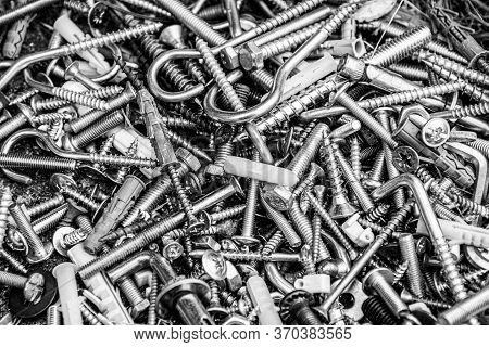 Pile Of Many Assorted Metalware Bolts And Nuts. Black And White Photo Of Work Tools Closeup. Abstrac