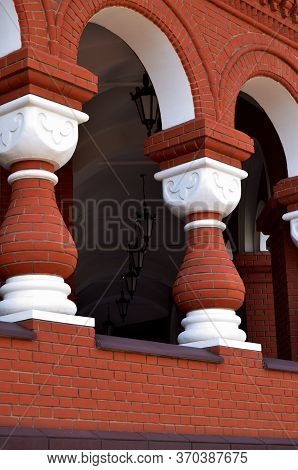 Columns With Red Brick Arches And Lanterns Under The Ceiling In The Corridor Vertical Orientation