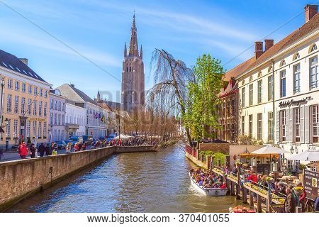 Bruges, Belgium - April 10, 2016: Scenic Cityscape With Medeivel Houses, Boat With Tourists In Brugg