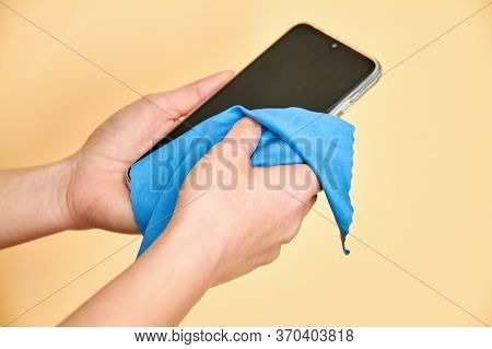 Female Hands Cleaning Mobile Phone For Covid-19 Disease Prevention. Virus Prevention.