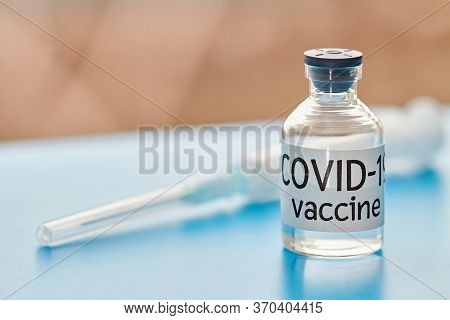 Conceptual Image. Vaccine Bottle And Syringes To Protect From Covid-19. Closeup, Blue Background. He
