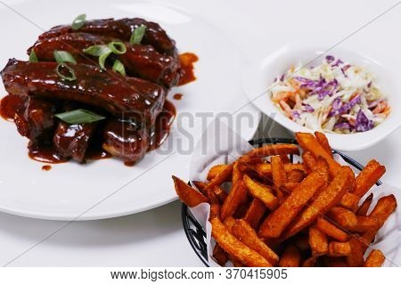 Pork Baby Ribs Glazed With Barbecue Sauce, With Sweet Potato Fries And Coleslow Salad