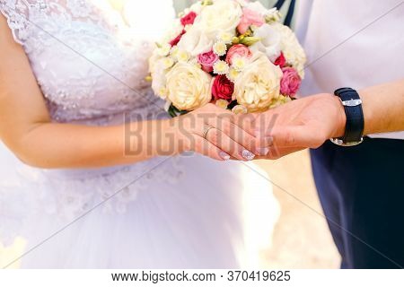 Detail Of Bride's Roses Bouquet And Hands Holding.