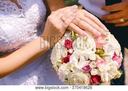 Detail Of Bride's Roses Bouquet And Hands Holding.