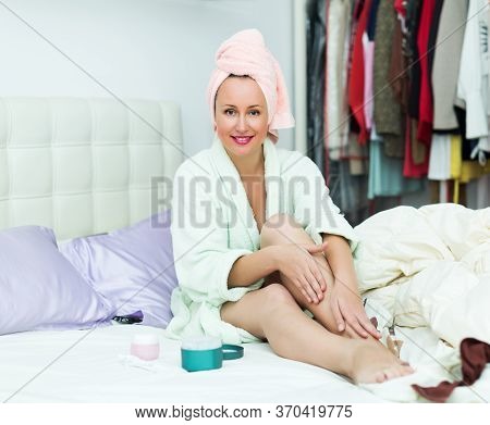 Happy Young Woman Taking Care Of Leg Skin After Shower