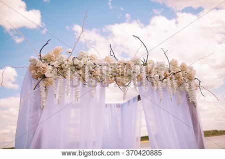Wedding. Ceremony. Wedding Arch. Wedding Arch Of Branches, Flowers And Greenery Stands On The Green 
