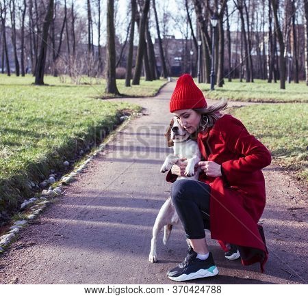 Pretty Young Girl In Redd Coat Playing With Dog Outside In Green Park, Lifestyle People Concept
