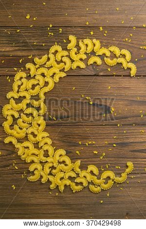 Pene Lisce Pasta In The Form Of The Month On Dark Wooden Background. Top Views.
