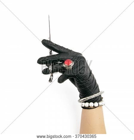 Gloved Hand Holding A Silver Scisors On An Isolated White Background.
