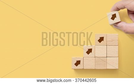 Hand Arranging Wood Block Stacking As Step Stair On Paper Yellow Background With Copy Space. Ladder 