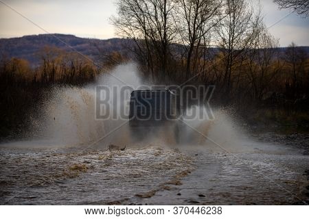 Offroad Car. Offroad Vehicle Coming Out Of A Mud Hole Hazard. Mudding Is Off-roading Through An Area