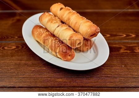 A Plate Of Hot Dogs Sitting On Top Of A Wooden Table