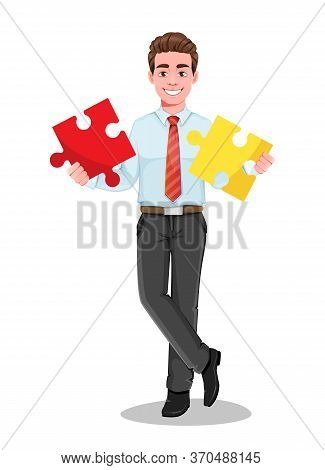 Successful Business Man Holding Two Pieces Of Puzzle. Handsome Businessman In Business Clothes. Chee