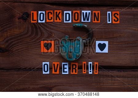 Lockdown Is Over Sign, Open Iron Lock On Wooden Background. Opening Borders Between Countries. End O