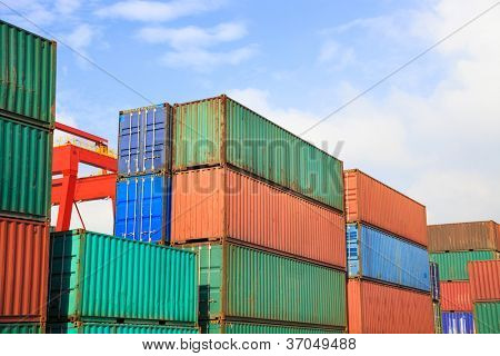 Stakken af fragtcontainere ved solopgang i en intermodal værftet